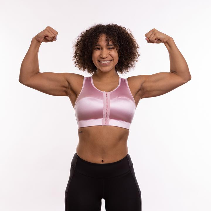 Image of woman flexing and wearing the Enell sports bra in pink
