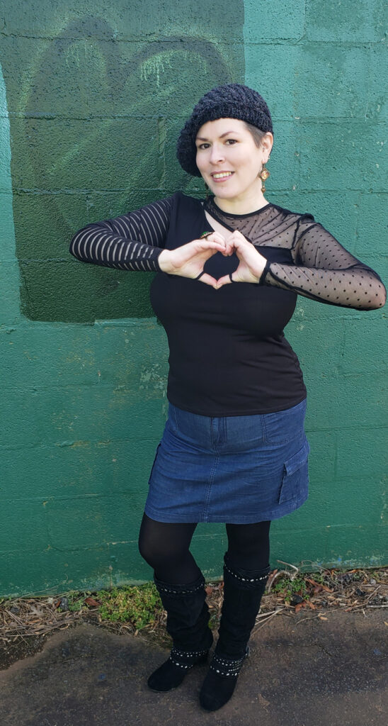 Pic of me making a heart shape with my hands next to a graffiti heart