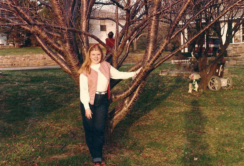 Image of my mom standing next to a tree when she was in her 20s.